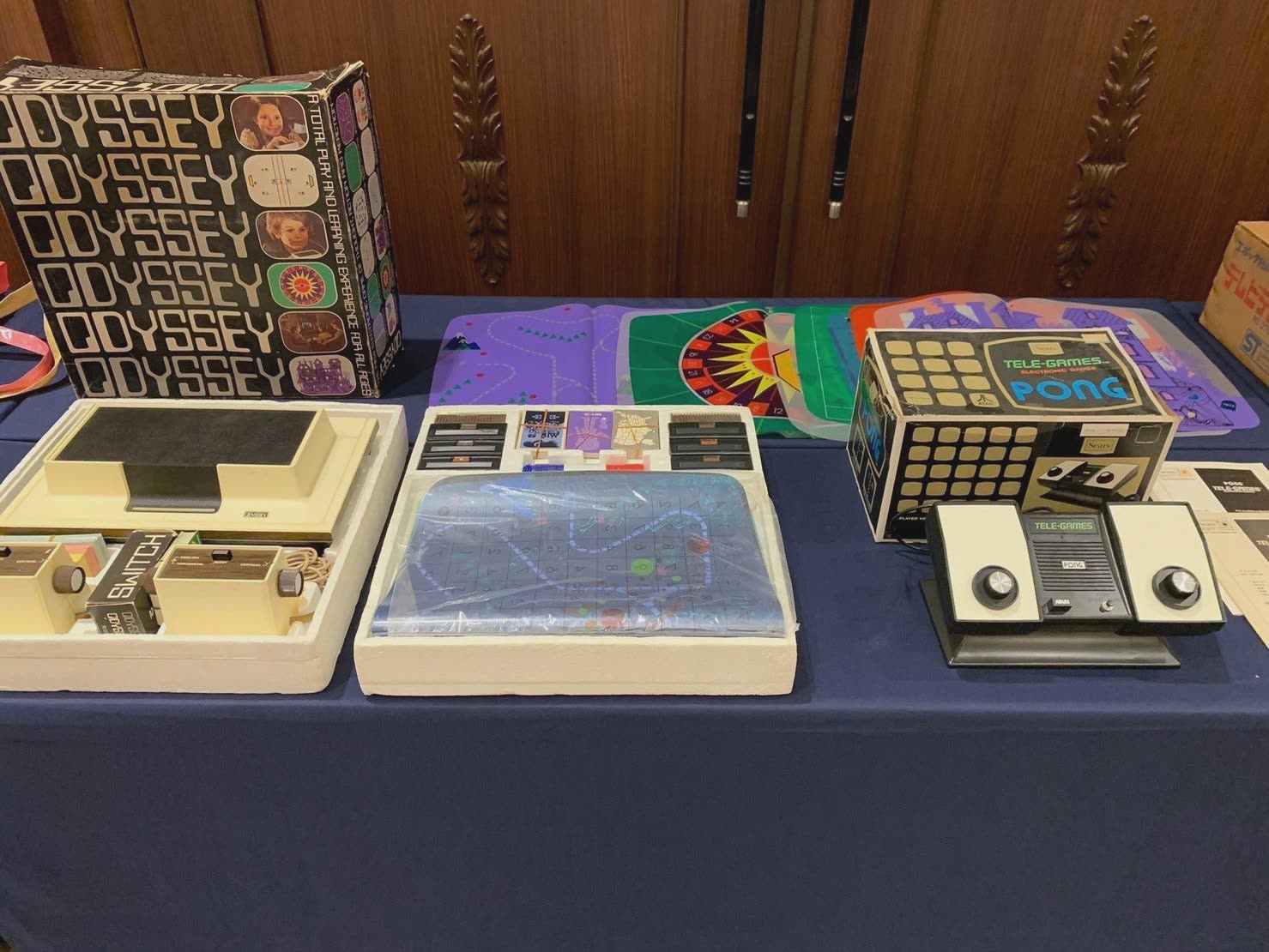 テーブルに並んだ海外の家庭用ゲーム機「オデッセイ」と付属のシート、「PONG」のゲーム機と箱